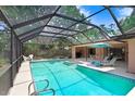 Relaxing screened-in pool area with lounge chairs and outdoor dining space at 107 Halton Cir, Seffner, FL 33584