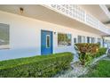 Exterior view of condo building with a blue front door and decorative lattice balcony at 11224 82Nd Ave # 104, Seminole, FL 33772