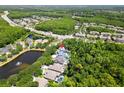 An aerial shot of a home surrounded by lush trees with a pond nearby and neighborhood at 11723 Gothic Ln, Tampa, FL 33626