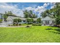 Charming single-story home featuring a well-manicured lawn, tidy landscaping, and a cozy outdoor patio with pergola at 118 S Manhattan Ave, Tampa, FL 33609