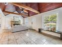Inviting living room with stone fireplace, wood ceiling, and travertine floors at 118 S Manhattan Ave, Tampa, FL 33609
