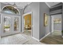 Inviting foyer with a decorative glass front door, tile flooring, and gray walls at 12009 Wandsworth Dr, Tampa, FL 33626