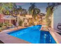 Sparkling pool with deck chairs amid lush landscaping offers a serene backyard retreat at 122 Miramar Ne Blvd, St Petersburg, FL 33704