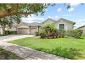 Beautiful single-story home showcasing lush landscaping and a three-car garage at 16104 Bridgedale Dr, Lithia, FL 33547