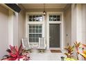Close-up of front porch featuring two chairs and decorative plants by the door at 16104 Bridgedale Dr, Lithia, FL 33547