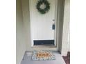 Inviting front door features a decorative wreath and a 'Home' welcome mat, adding a warm touch at 1841 Georgia Ave, Palm Harbor, FL 34683