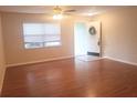 Bright living room featuring hardwood floors, a ceiling fan, and a window letting in natural light at 1841 Georgia Ave, Palm Harbor, FL 34683