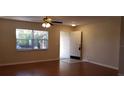 Bright living room with hardwood floors, a ceiling fan, and a large window at 1841 Georgia Ave, Palm Harbor, FL 34683