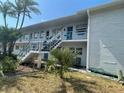 White condo building with blue accents, staircase, and tropical landscaping at 1921 58Th N Ave # 11, St Petersburg, FL 33714