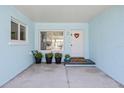 Inviting front porch with a charming white door, potted plants, and a cozy welcome mat at 2010 20Th Avenue Pkwy, Indian Rocks Beach, FL 33785