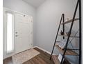 Inviting entryway features wood-look tile flooring, ladder shelf decor, and natural light from sidelight window at 2816 Grand Kemerton Pl, Tampa, FL 33618
