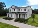 Stunning two-story home featuring black metal roof accents, a covered entry, and landscaped frontage at 2890 Alexandria Marie Ln, Lutz, FL 33559