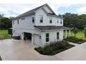 An exterior side view showcases a two-car garage and lush landscaping at 2890 Alexandria Marie Ln, Lutz, FL 33559