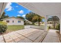 Covered outdoor patio area with brick flooring, perfect for relaxing and enjoying the backyard view at 2956 Sutherland Ct, Palm Harbor, FL 34684