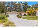 Attractive single-level home with a long driveway, spacious garage, and lovely front yard landscaping at 2956 Sutherland Ct, Palm Harbor, FL 34684