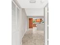 Inviting hallway features neutral walls, tile flooring, and a view into the open kitchen at 2986 Cypress Green Dr, Palm Harbor, FL 34684