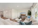 Bright living room with hardwood floors, modern furniture, and a large window for natural light at 3050 Pink Gerbera Sq, Plant City, FL 33566