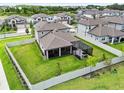 Aerial view of a backyard with a large, green lawn, white fence, and screened-in patio at 33287 Sycamore Leaf Dr, Wesley Chapel, FL 33545