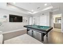 Spacious bonus room with a pool table, mounted TV, and modern decor at 33287 Sycamore Leaf Dr, Wesley Chapel, FL 33545
