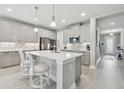 Beautiful kitchen with a center island, stainless steel appliances, modern cabinets and stylish backsplash at 33287 Sycamore Leaf Dr, Wesley Chapel, FL 33545