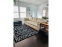 Bright living room featuring a comfortable sofa, stylish rug, and dark hardwood floors at 4049 Ponea Dr, Sarasota, FL 34241