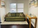 Cozy living room features a green sofa, throw pillows, and natural light at 4049 Ponea Dr, Sarasota, FL 34241