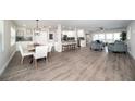 Bright open-concept living space with wood flooring, recessed lighting, and access to the kitchen and dining area at 415 Mission Hills Ave, Temple Terrace, FL 33617