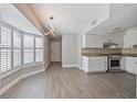 Open-concept kitchen with white cabinets, granite countertops, tile backsplash, stainless steel appliances, and tiled floors at 4463 Vieux Carre Cir, Tampa, FL 33613