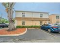 View of the exterior of a two-story tan condominium building, showcasing parking spaces at 4708 Michael Ct # 103, Tampa, FL 33614