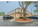 Exterior of a two-story tan condominium building with trees and parking spots at 4708 Michael Ct # 103, Tampa, FL 33614