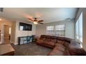 Spacious living room with ceiling fan, large windows, and a comfortable wrap around couch at 4735 W Leila Ave, Tampa, FL 33616