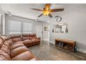 Bright living room with stylish flooring, ceiling fan, and pass-through window to the kitchen at 4735 W Leila Ave, Tampa, FL 33616