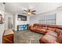 Comfortable living room featuring a plush leather sofa, ceiling fan, and modern flooring at 4735 W Leila Ave, Tampa, FL 33616