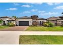 Charming single-Gathering home boasting stone accents, tile roof, manicured lawn, and brick driveway at 4795 Freccia Loop, Wesley Chapel, FL 33543