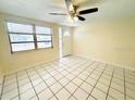 Bright living room featuring tile floors, ceiling fan, and large windows for ample natural light at 4836 Daphne St, New Port Richey, FL 34652
