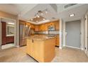 Bright kitchen featuring stainless steel appliances, granite countertops, central island, and tile flooring at 4900 Brittany S Dr # 613, St Petersburg, FL 33715