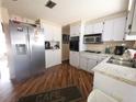 Functional kitchen with white cabinets, granite counters, and stainless steel refrigerator at 4902 Panorama Ave, Holiday, FL 34690