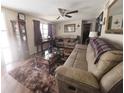 Cozy living room with wood-look floors, plush seating, and natural light at 4902 Panorama Ave, Holiday, FL 34690