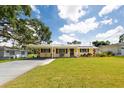 Charming single-story home with a lush green lawn, covered front porch, and carport with solar panels at 5675 Lown N St, St Petersburg, FL 33714