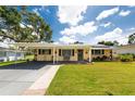 Charming single-story home with a lush green lawn, covered front porch, and carport at 5675 Lown N St, St Petersburg, FL 33714