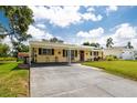 Charming single-story home with a lush green lawn, covered front porch, and long driveway at 5675 Lown N St, St Petersburg, FL 33714