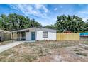 Single-story home featuring a screened porch and a freshly painted exterior with newer landscaping and a wood fence at 6014 S 82Nd St, Tampa, FL 33619