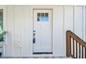 A well-lit front door framed by white trim and siding creates a clean, inviting entryway to the residence at 6433 Werner Ave, New Port Richey, FL 34652