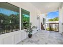 Charming tiled porch with white trim, providing a welcoming entrance to the home and views of the neighborhood at 6433 Werner Ave, New Port Richey, FL 34652