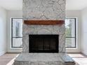 Stunning stone fireplace with wooden beam mantel between windows in an open living area at 6602 Winding Brook Dr, New Port Richey, FL 34655