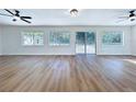 Large living room with updated floors, neutral paint, modern ceiling fans, and lots of natural light at 6602 Winding Brook Dr, New Port Richey, FL 34655