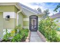 Inviting front entrance with a screened door, beautiful landscaping, and a stone walkway at 6628 Summer Haven Dr, Riverview, FL 33578