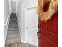 Modern foyer with a striking red door featuring a smart lock and stairs leading to the upper level at 807 Callista Cay Loop, Tarpon Springs, FL 34689