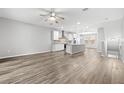 Spacious open-concept living room featuring wood floors, recessed lighting, ceiling fan, and kitchen view at 807 Callista Cay Loop, Tarpon Springs, FL 34689
