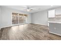 Inviting living room with wood floors, ceiling fan, neutral paint, and a sliding glass door to the balcony at 807 Callista Cay Loop, Tarpon Springs, FL 34689